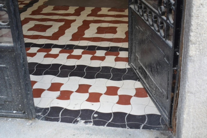 Ornate geometric floor tiles in black, white, and red.